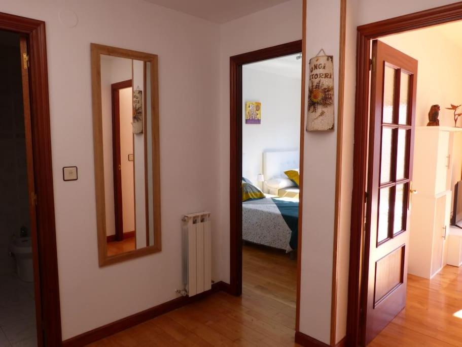 a hallway with two mirrors and a room with a bed at Eguzkilore - Apartamento luminoso y soleado in Elizondo