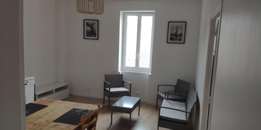 une chambre avec des chaises, une table et une fenêtre dans l'établissement Appartements simples et fonctionnels, à Pamiers