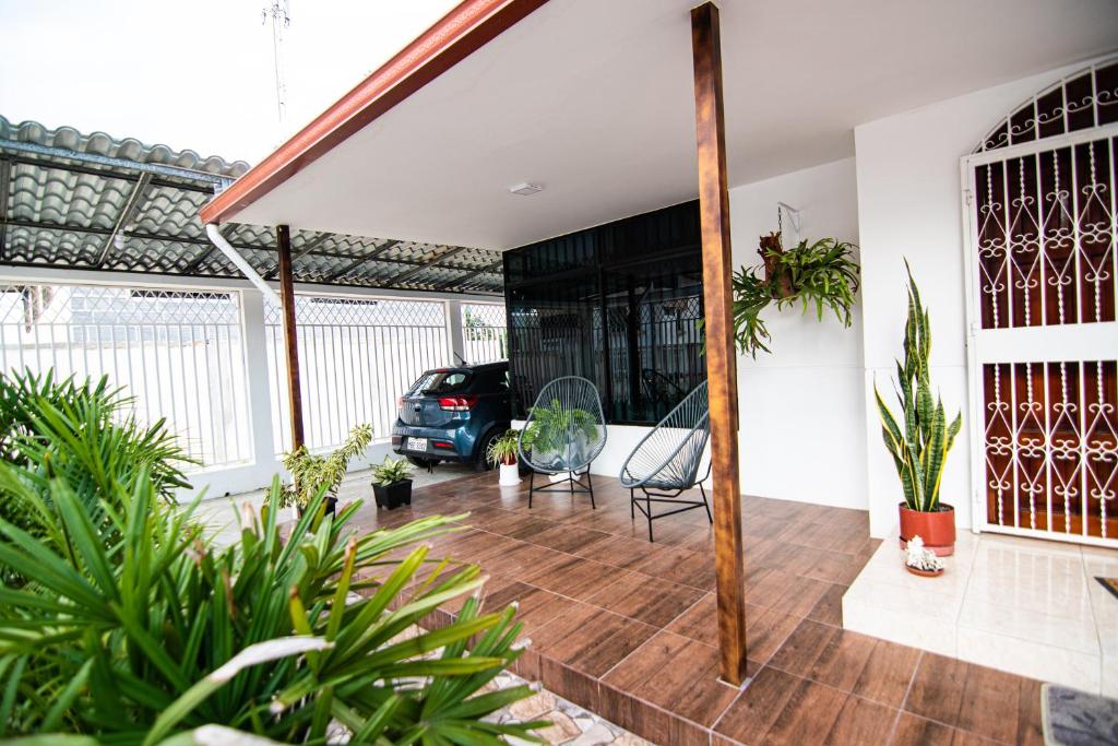 una sala de estar con plantas y un coche en una casa en Habitaciones privadas, Casa de Amber, Manta, en Manta