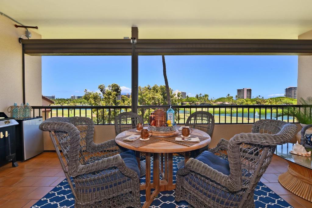 a dining room with a table and chairs on a balcony at Kaanapali Royal D302 in Lahaina