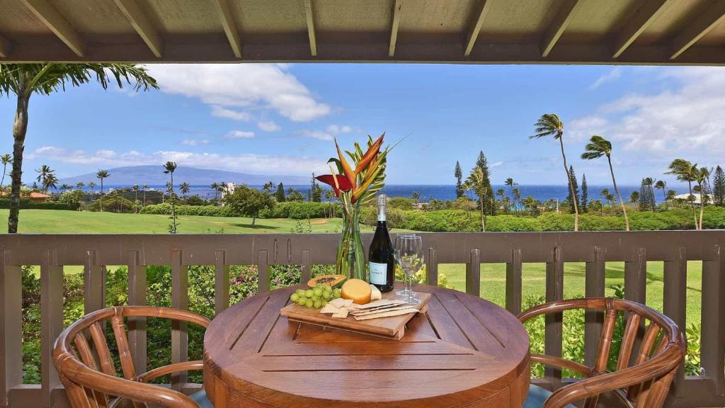 a wooden table with a bottle of wine and a glass at Kaanapali Plantation 8 in Lahaina