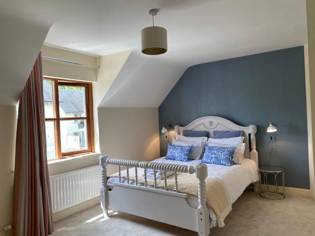 a bedroom with a bed with a blue accent wall at Kilronan 4 Bed House on castle grounds in Ballyfarnon