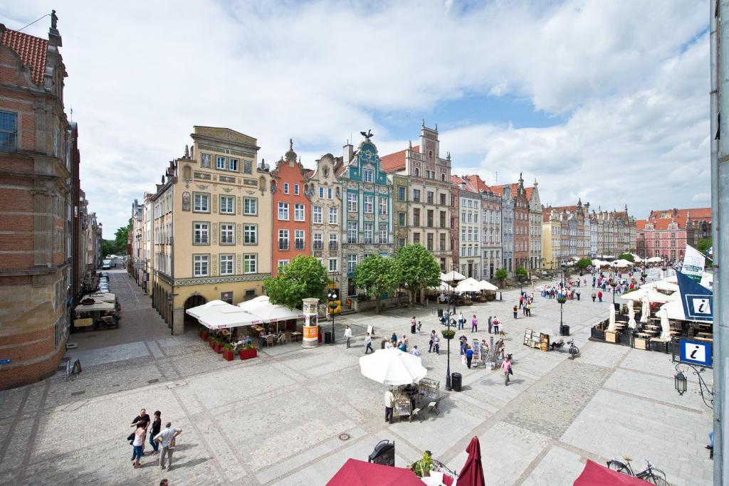 a group of people walking around a city with buildings at YOURAPART Gdańsk Starówka in Gdańsk