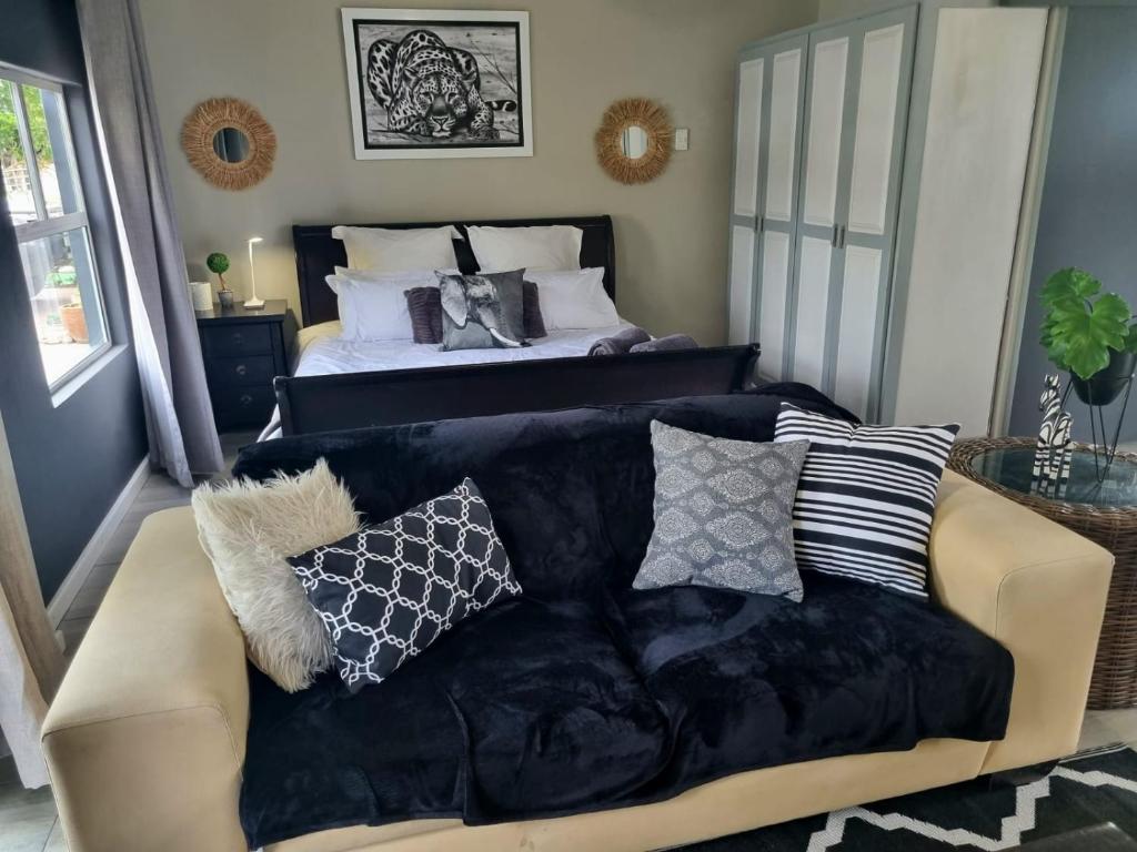 uma sala de estar com um sofá e uma cama em Angel 8 AirBnB Apartment 1 em Robertson