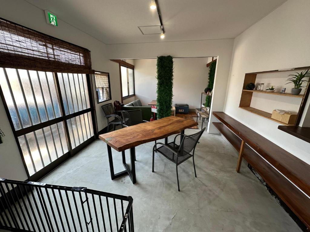 a living room with a wooden table and chairs at Monster lodge 西伊豆 in Nishina
