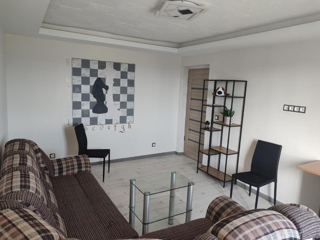 un soggiorno con un divano e un tavolo di vetro di CHESS Apartment a Ventspils