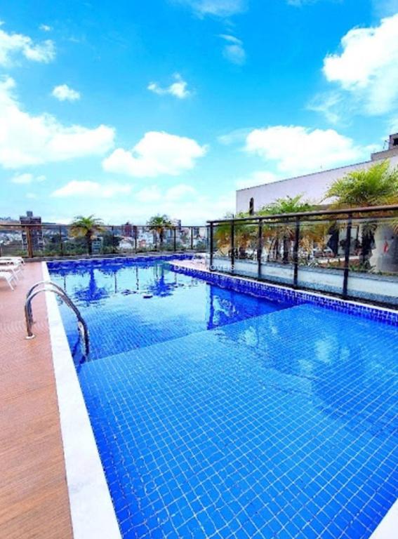 a large swimming pool with blue tiles on a building at Apartamento Le Quartier - no centro, dois quartos, wi-fi, garagem, piscina, ar-condicionado, jacuzzi, sauna, etc in Juiz de Fora
