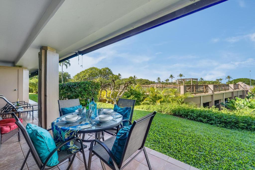 a patio with a table and chairs and a view of a bridge at Eldorado K103 in Kahana