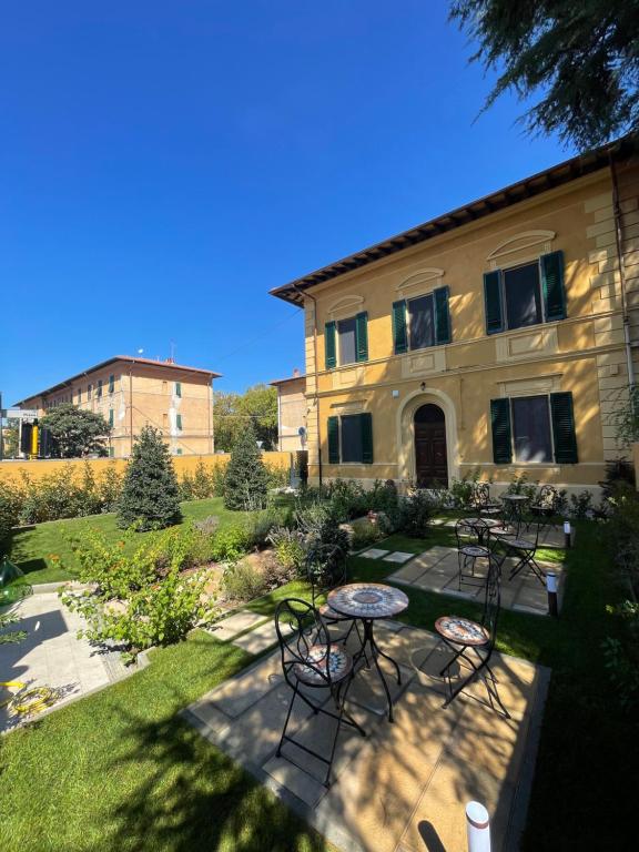 eine Terrasse mit Tischen und Stühlen vor einem Gebäude in der Unterkunft Villa Natalina B&B in Pisa