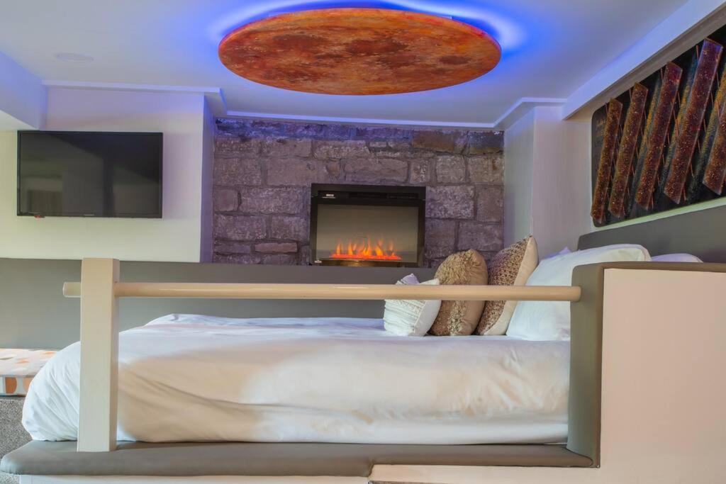 een slaapkamer met een bed en een open haard bij NAPA Suite • Hot Tub • Downtown • Original Art in Eureka Springs