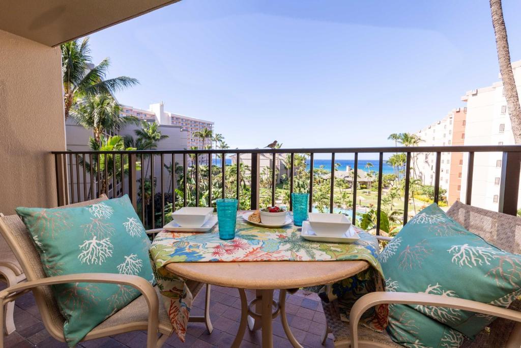 a table and chairs on a balcony with a view of the ocean at Kaanapali Shores 527 in Kahana