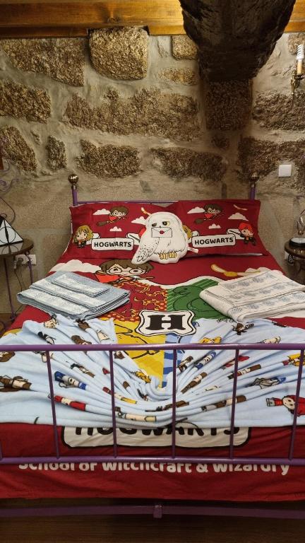 a bed with a blanket on top of it at Casa da Relva Experiência Temática Inspirada em Harry Potter in Lamego