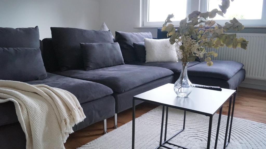 a living room with a couch and a vase of flowers on a table at Ferienwohnung Siegen in Siegen