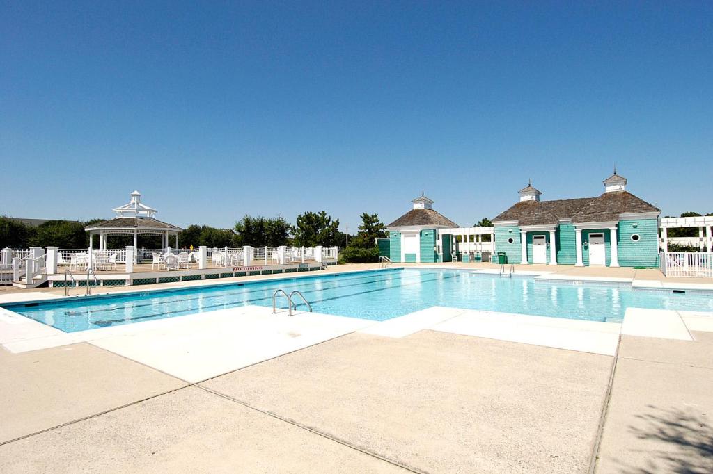 una gran piscina rodeada de sillas blancas. en 1606 - Shades of Sand by Resort Realty, en Corolla