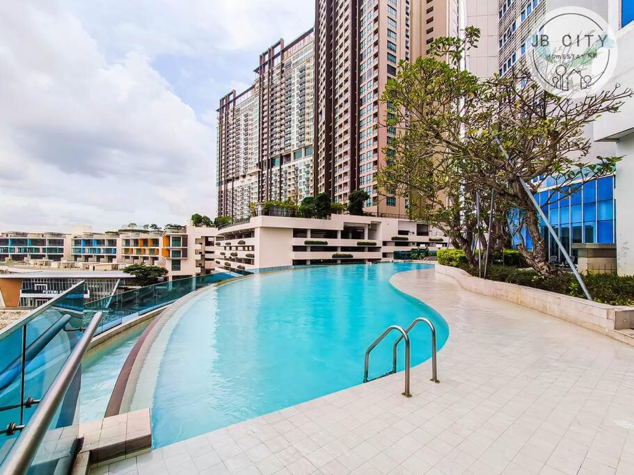 Kampong BaharuPine Tree Suites by RR JBcity的一座大型游泳池,位于部分建筑前