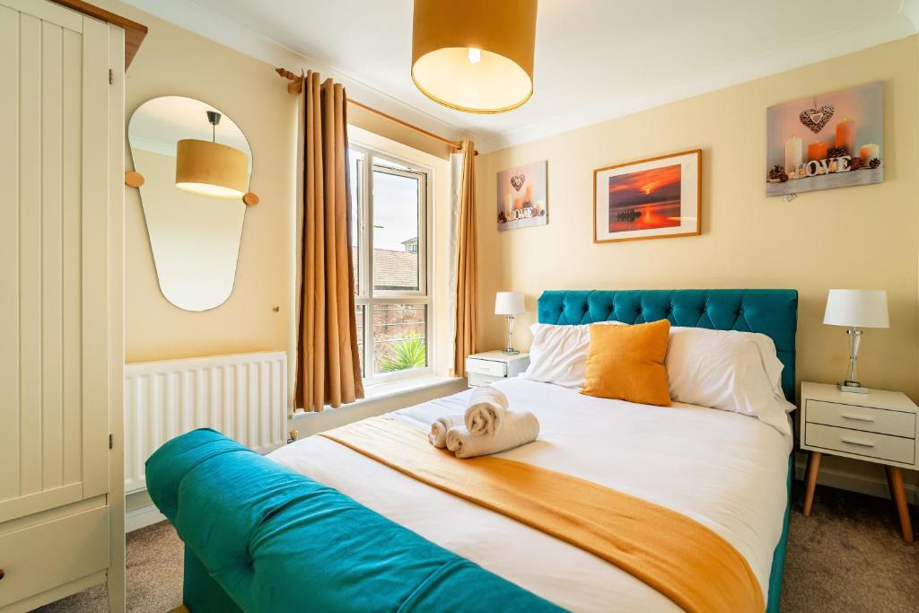 a bedroom with a large bed with a blue headboard at Luxury Riverview 2Bed Apt- 5 mins from Excel London, Canary wharf, 02 Arena - Free Parking - PlayStation 4 Provided in London