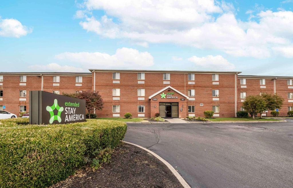 un grand bâtiment en briques avec un panneau devant lui dans l'établissement Extended Stay America Suites - Evansville - East, à Evansville