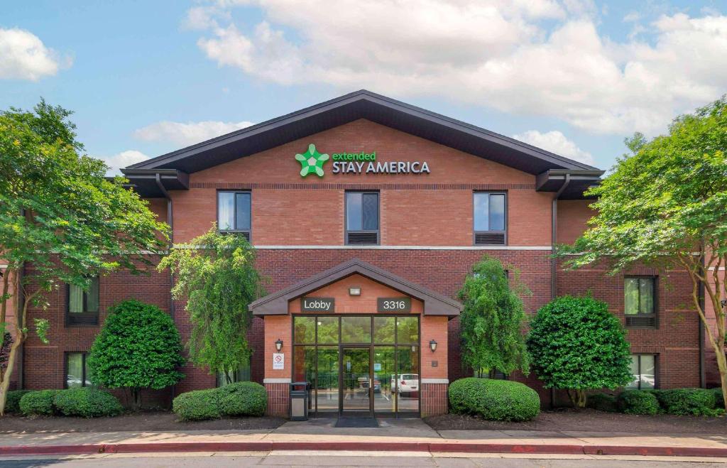 Un gran edificio de ladrillo rojo con un cartel. en Extended Stay America Select Suites - Atlanta - Kennesaw Chastain Rd, en Kennesaw