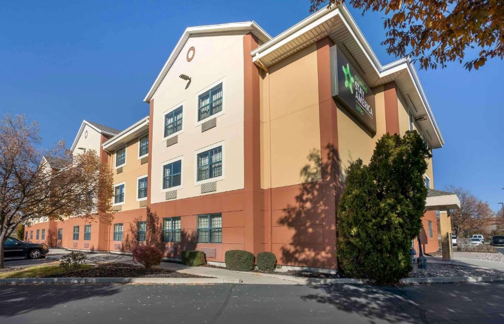 a large brick building with a tree in front of it at Extended Stay America Suites - Salt Lake City - West Valley Center in West Valley City