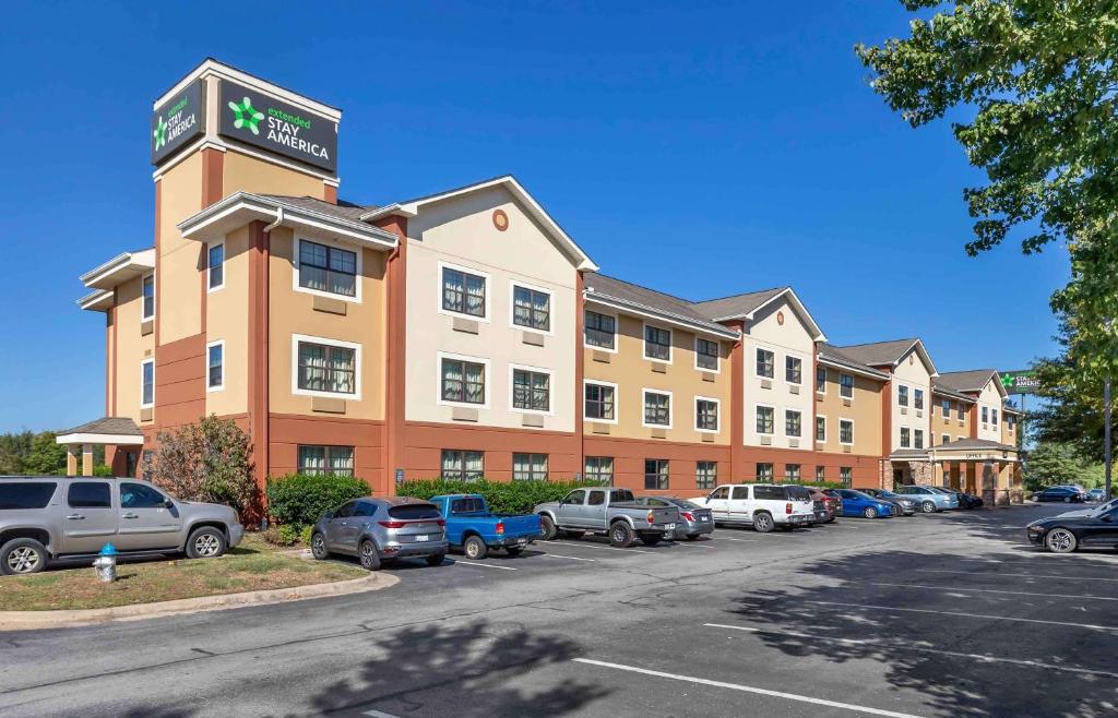 a hotel building with cars parked in a parking lot at Extended Stay America Select Suites - Fayetteville - Springdale in Springdale