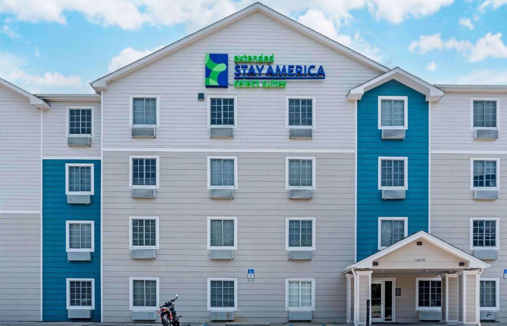 ペンサコーラにあるExtended Stay America Select Suites - Pensacola - Northeastの看板が貼られた白い大きな建物