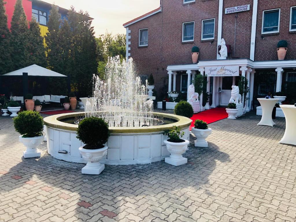 une fontaine dans une cour en face d'un bâtiment dans l'établissement Hotel Bouzid - Laatzen, à Hanovre