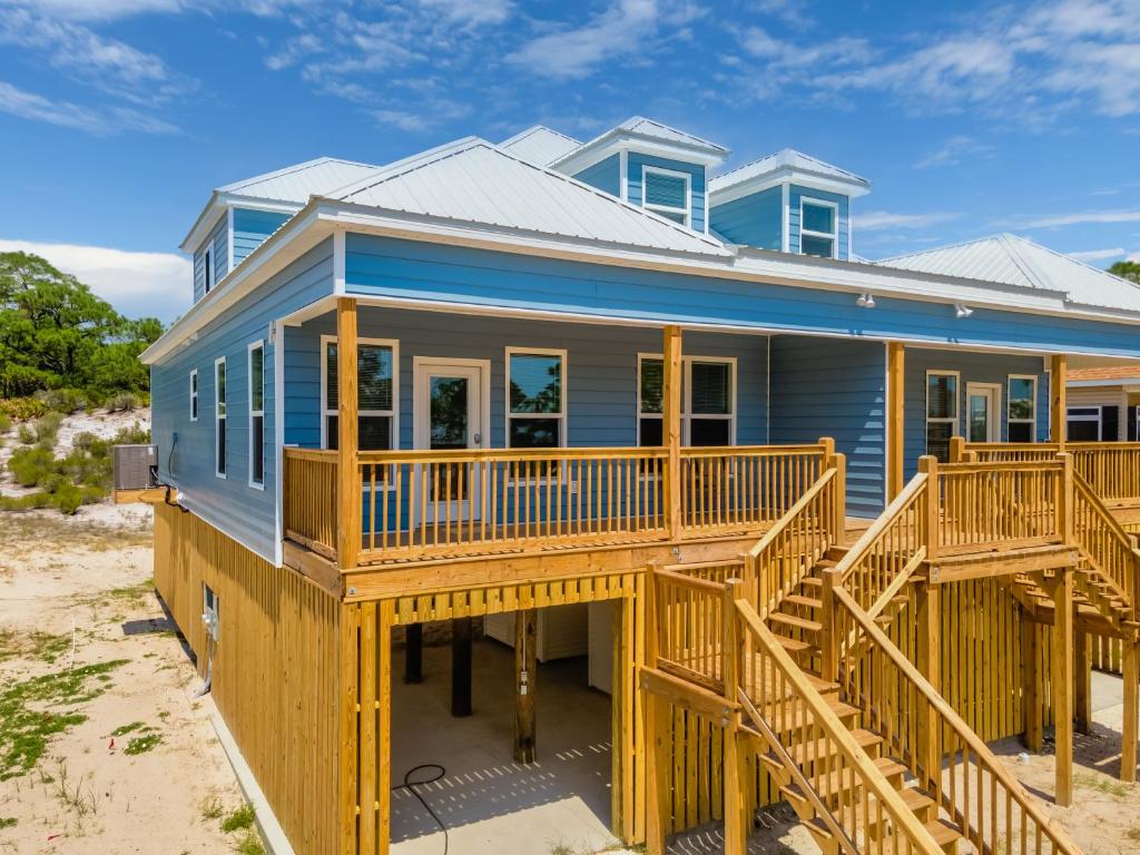 une maison bleue avec une terrasse sur la plage dans l'établissement Southern Dunes West - 332 Audubon Pl Unit A home, à Dauphin Island