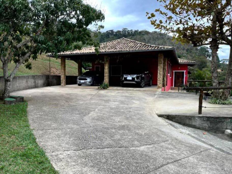a garage with two cars parked in a driveway at Casa em Secretário (@chacaradosolsecretario) in Petrópolis