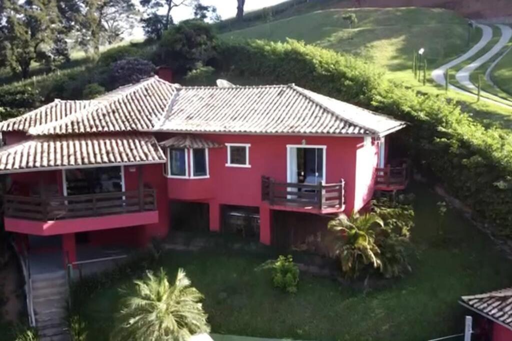 a red house on the side of a hill at Casa em Secretário a 800 metros do centro de Secretário chacaradosolsecretario in Petrópolis