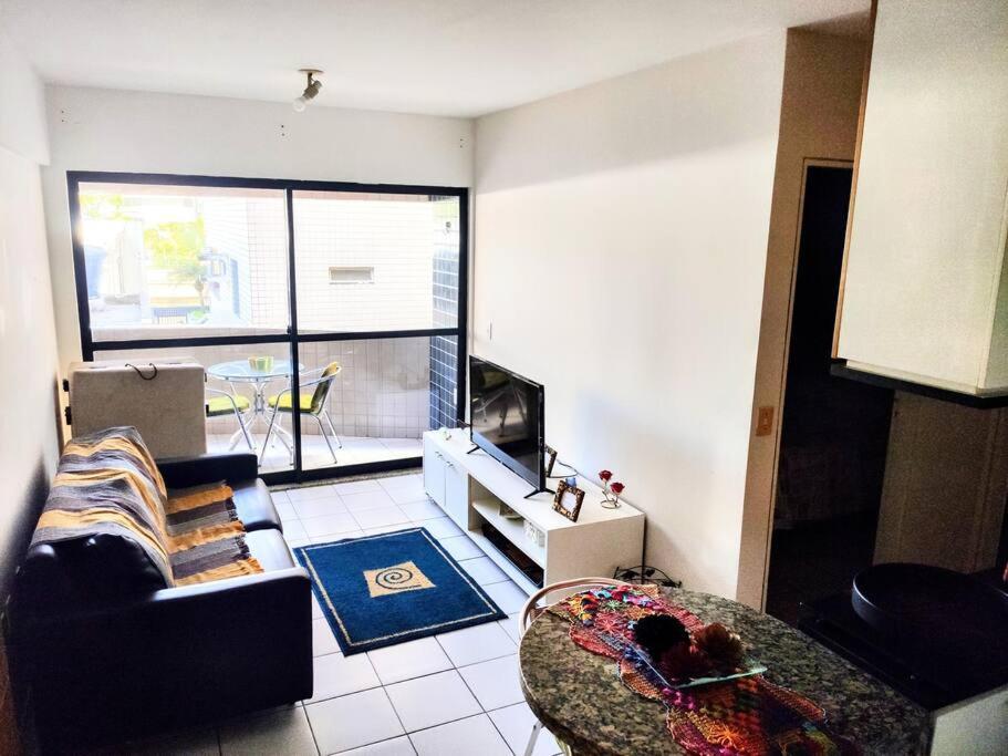 a living room with a couch and a table at Apartamento Praia de Ponta Verde com um quarto in Maceió