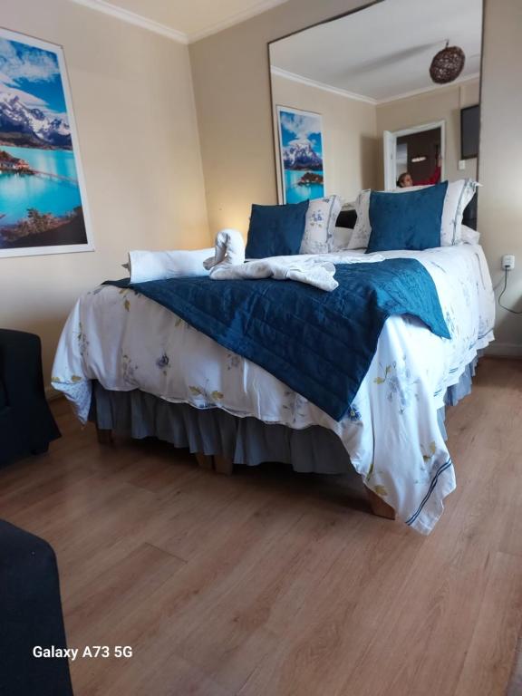 1 dormitorio con 1 cama grande con sábanas azules y blancas en Hostal Chile Chico, en Santiago
