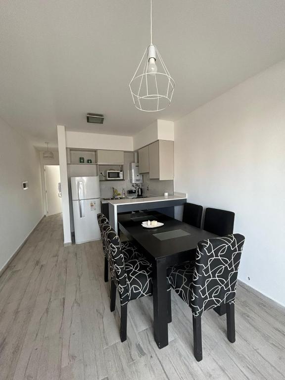 a kitchen with a black table and chairs in a room at Moderno dpto céntrico 1 dormitorio , luminoso y cómodo , con cochera opcional in Santa Fe