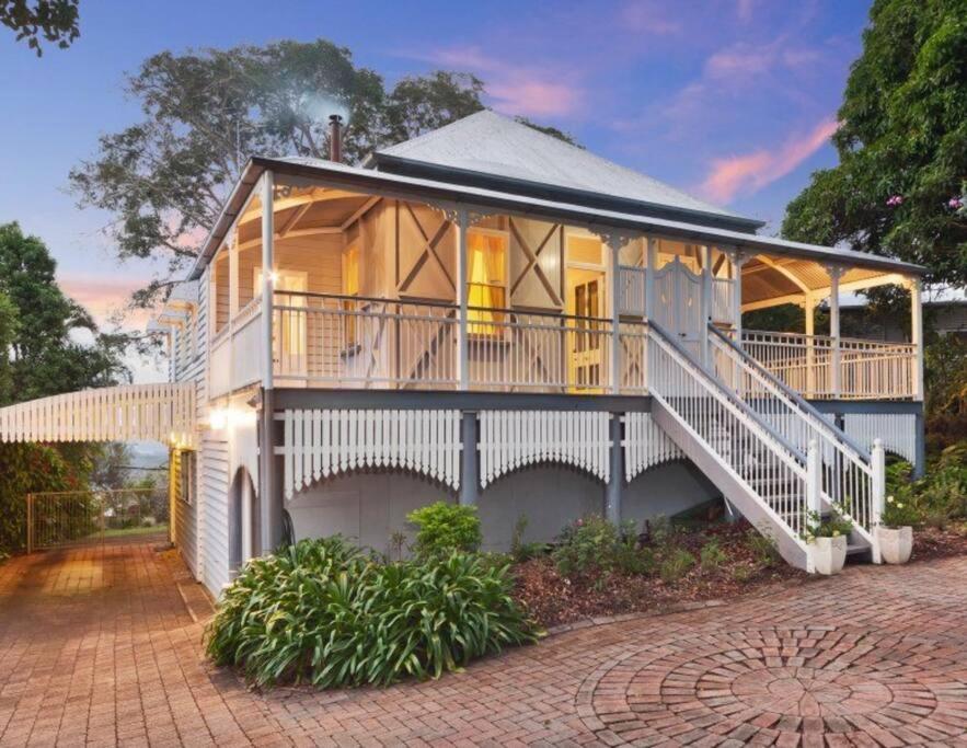 a large white house with a porch and stairs at Buderim Milne House in Buderim