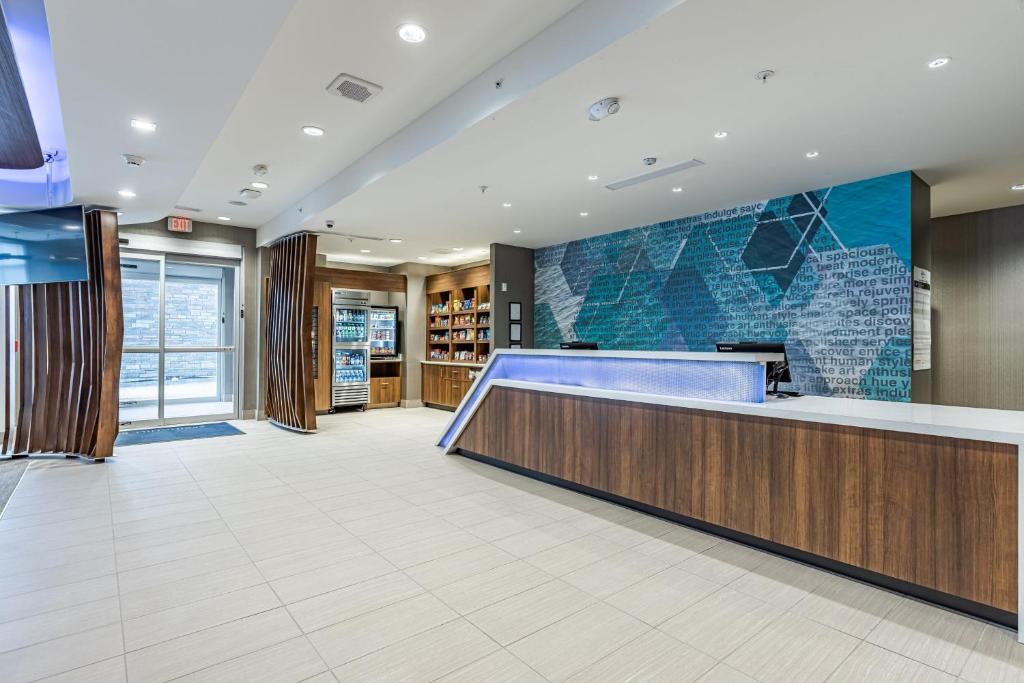 a lobby with a blue counter and a library at SpringHill Suites by Marriott Detroit Sterling Heights in Sterling Heights