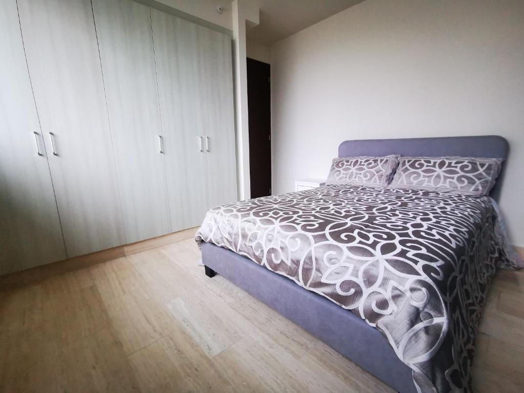 um quarto com uma cama com um edredão branco em Beautiful Apartment 2 BR na Cidade do Panamá