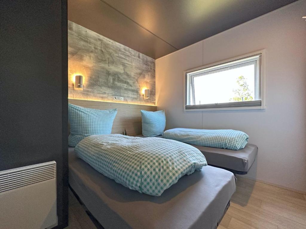 Postel nebo postele na pokoji v ubytování Seeblick holiday village premium tiny house with sauna and hot tub