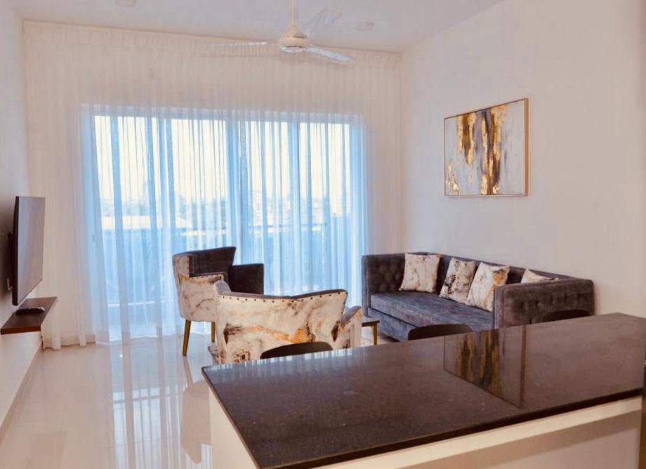 a living room with a couch and a table at SkyGate Residences in Nugegoda