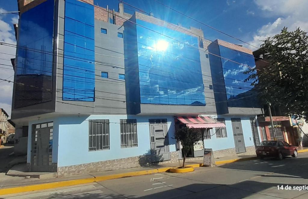 un edificio azul y blanco en una calle de la ciudad en Hostal Pura Casta en Carhuaz