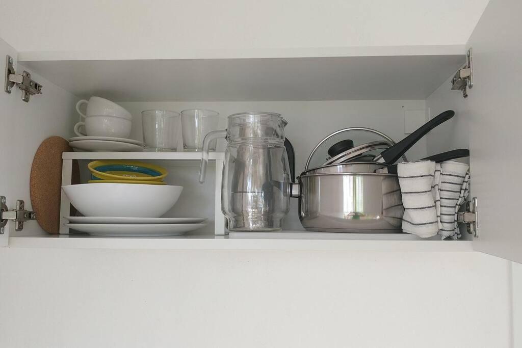 a kitchen shelf with dishes and utensils at Quédate Aquí in Las Galeras