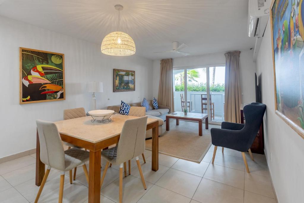 a dining room and living room with a table and chairs at Caribbean Oasis on Sunset Beach in Maho Reef