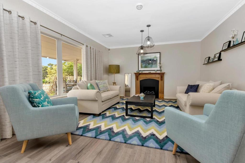 a living room with two chairs and a fireplace at Mid Century 4 Bedroom Getaway in Barossa Vineyard in Nuriootpa