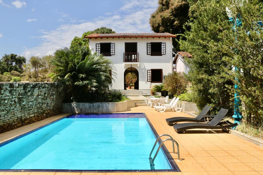 a villa with a swimming pool and a house at Casa de Novela in Pirenópolis