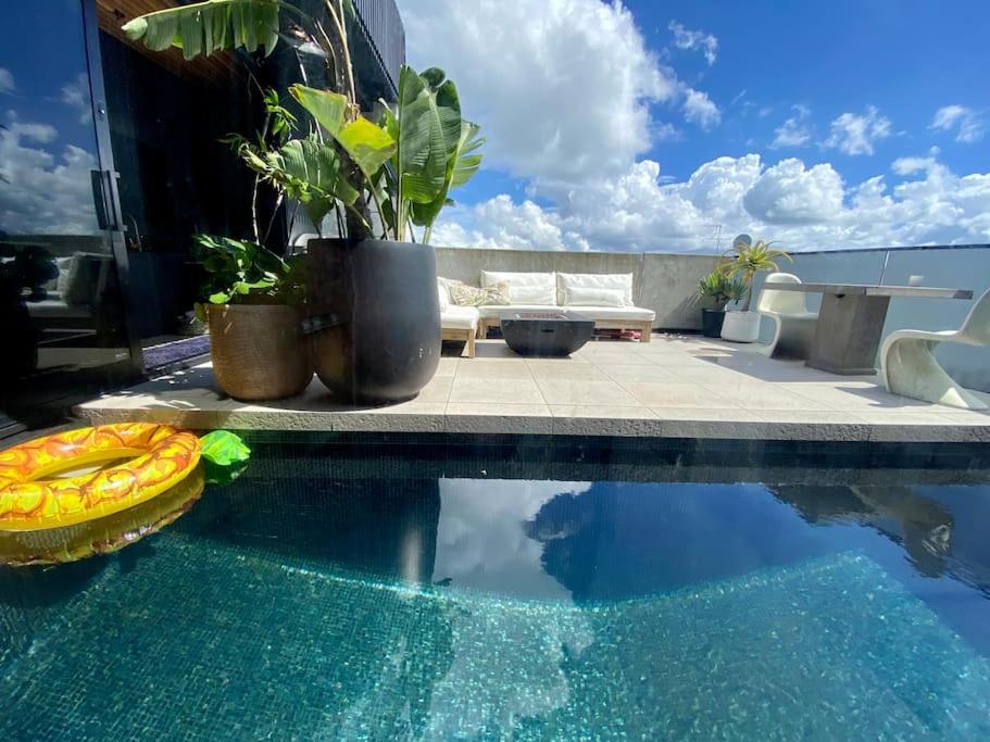 a swimming pool with a table and a couch at Entertainers penthouse with 5 bedrooms pool & spa in Auckland