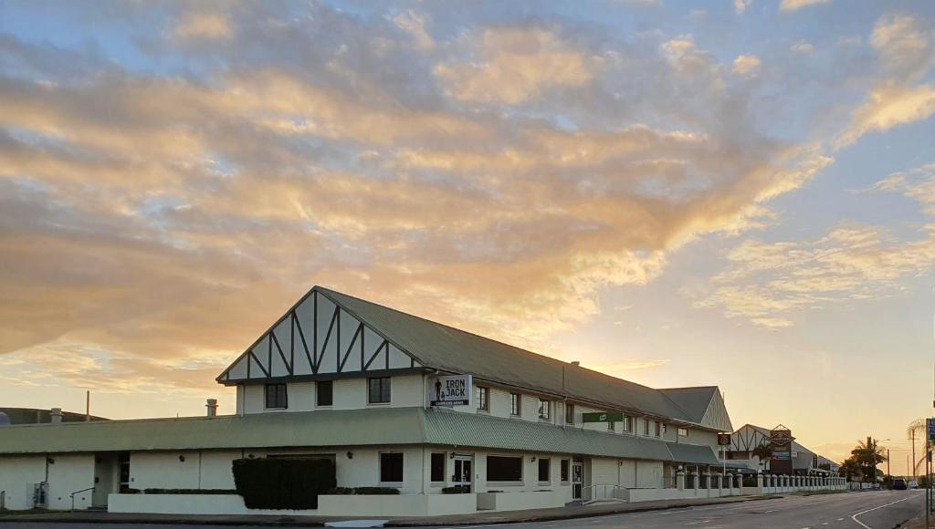 ein Gebäude an der Seite einer Straße mit wolkigem Himmel in der Unterkunft Carriers Arms Hotel Motel in Maryborough