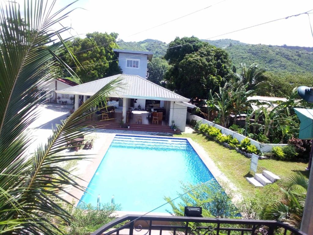 ein Haus mit einem Pool vor einem Haus in der Unterkunft Beachfront Mansion and Seascape Villas Calatagan with Outdoor Pool in Calatagan