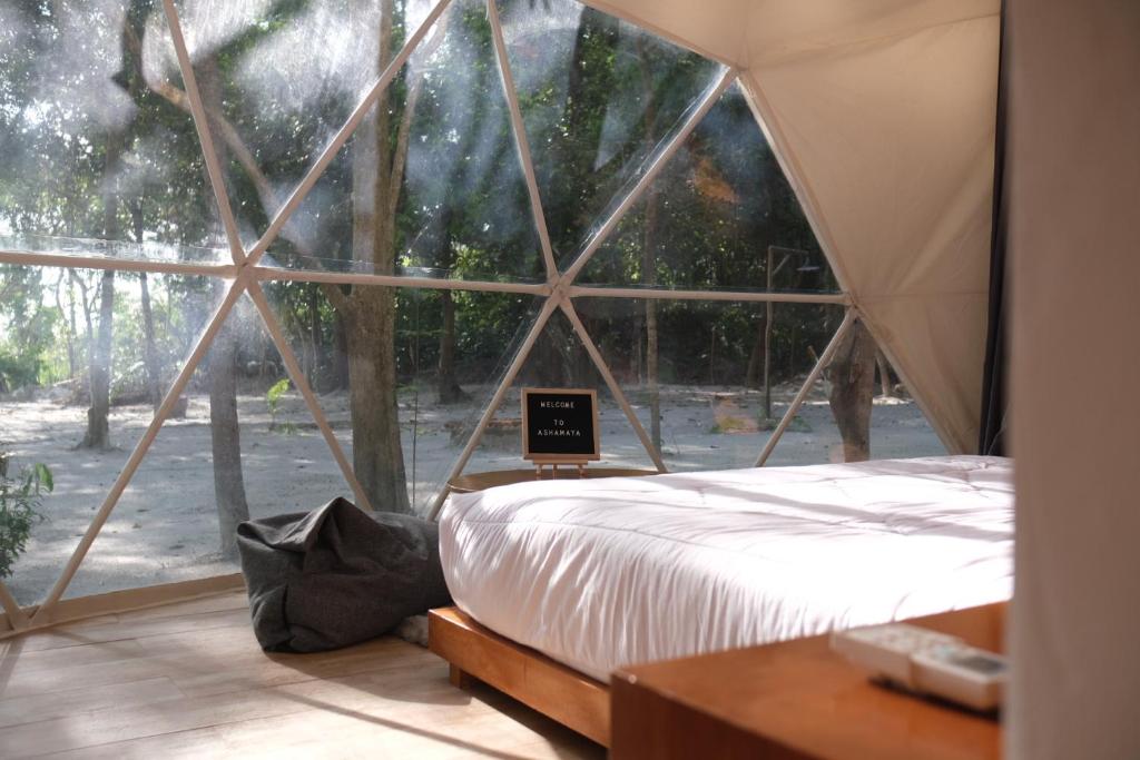 a bedroom with a tent with a laptop on a bed at Ashamaya Belitung (Dome Glamping Site) in Pasarbaru