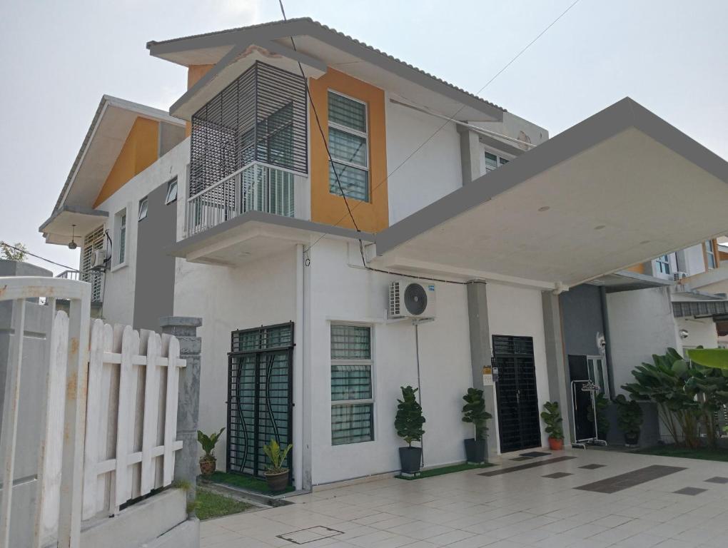 une maison blanche avec une clôture devant elle dans l'établissement Sarrah Homestay At Kasa Height Residence, à Kampong Alor Gajah
