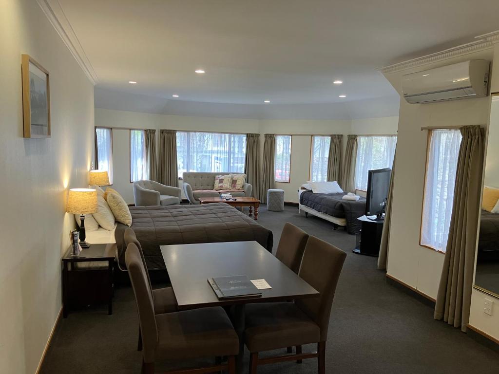 a hotel room with a bed and a living room at Fitzherbert Castle Motel in Palmerston North