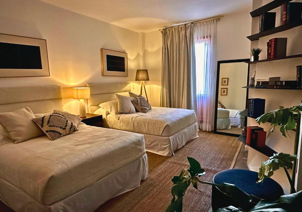 una camera d'albergo con due letti e un divano di The Isabel Hotel a Sombrerete