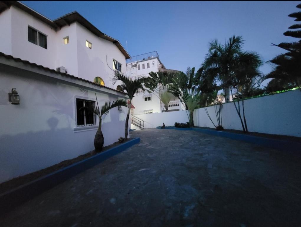 ソスアにあるCasa angelinaのヤシの木が前に立つ大きな白い建物